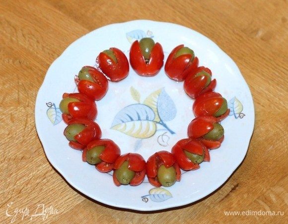 В каждом помидорчике черри (сверху) делаем острым ножиком крестообразный разрез. Кладем в разрез оливки б/к и маслины б/к, получается 18 шт.