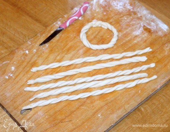 Раскатываем тонко оставшееся тесто в пласт и нарезаем 6 полосок, шириной 2 см. Скручиваем полоски теста в жгутики.