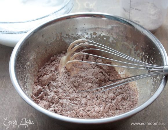 Для бисквитной основы взбейте желтки с сахаром, пока сахар полностью не растворится (5-7 минут). Смешайте муку вместе с какао порошком и просейте треть смеси во взбитые желтки. 