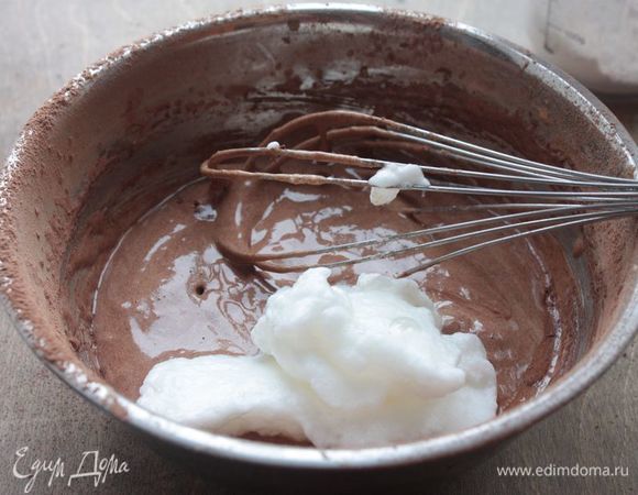 В отдельной миске взбейте до твердых пик яичные белки. Поочередно добавляйте шоколадно-яичную смесь белки и муку с какао, каждый раз тщательно вымешивая, чтобы получилось гладкое бисквитное тесто.