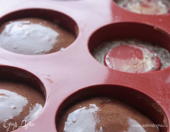 Отправьте формы с чизкейком в духовку. У меня слой чизкейка получился достаточно тонким, поэтому я выпекала его при 150°С в течение 10 минут. Нужно, чтобы он схватился и пропекся почти до готовности. Если у вас слой чизкейка толще, то увеличивайте время и следите за готовностью. Достаньте форму из духовки, дайте чизкейку остыть пару минут и залейте поверх него бисквитное тесто. И снова отправьте в духовку, где пеките уже до готовности (у меня ушло около 10 минут).