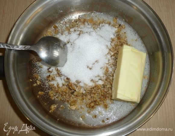 Белок взбить, переложить в сотейник с грецкими орехами, сахаром и 75 г масла. Готовить пару минут на слабом огне, помешивая. Остудить.
