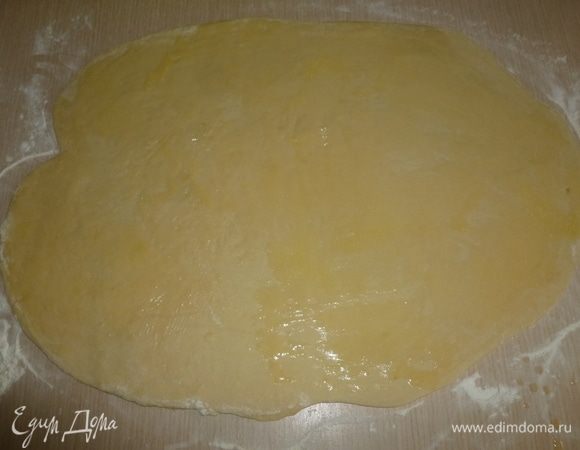 Тесто обмять, раскатать в прямоугольник 65х45 cм. Растопить оставшееся масло и смазать тесто.