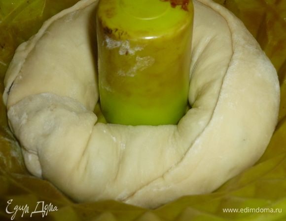 Смазать маслом кольцевую форму для кекса (22 см). Выложить рулет в форму по кругу швом вверх. Накрыть пленкой и оставить на 1 час в теплом месте. Разогреть духовку до 180°C. Выпекать рулет 40-45 минут.