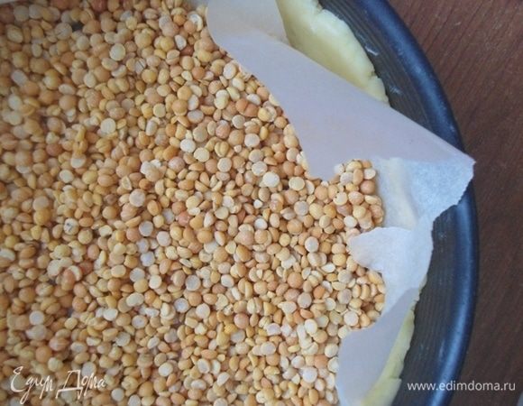 Переложить тесто в форму (у меня 26 см), пергаментом вверх. Засыпать какой-нибудь груз типа фасоли или гороха, и поставить в разогретую духовку до 180°С на 15 минут.