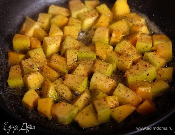 В глубокой сковороде разогреть 1 ст. л. растительного масла, добавить вторую половину тыквы, посыпать сухими итальянскими травами (розмарин, тимьян и др.).