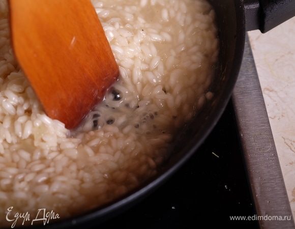 Через примерно 10-15 минут готовки нужно проверить рис на готовность. Рис должен быть плотным внутри, но не сырым, не хрустящим. Под конец готовки рис отдаст большое количество крахмала, поэтому структура ризотто будет вязкой — так и должно быть. Если лопаткой провести по дну сковороды, то жидкость с рисом должна медленно заполнять пространство.