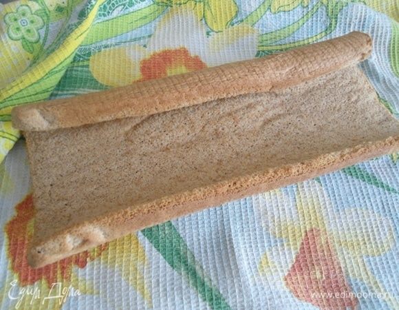 Готовый пласт освободить от бумаги и завернуть вместе с чистым кухонным полотенцем в рулет. Оставить до полного остывания.