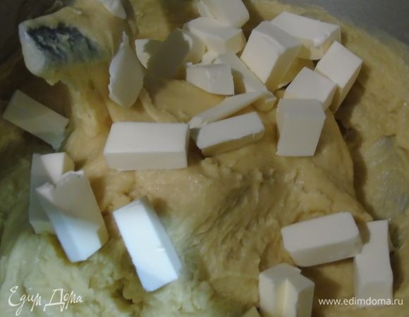 Добавить нарезанное кусочками сливочное масло и вымешивать, пока все масло не войдет, и тесто не начнет отходить от стенок чаши.