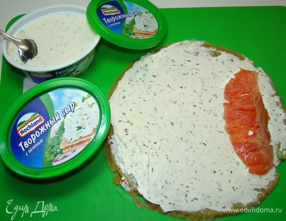 Готовые блинчики смазать сливочным сыром, уложить ломтик рыбы с одной стороны и свернуть рулетиком.
