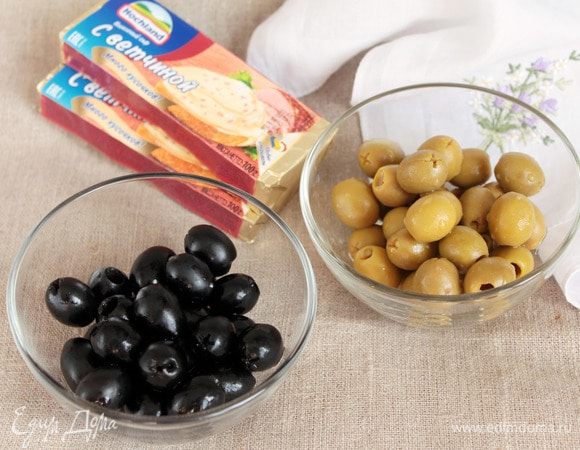 Для приготовления закусочных шариков первым делом подготовим оливки черные и зеленые (по 1 банке), которые должны быть без косточек. Самый маленький вес чистого продукта я брала 90 г одного сорта и оливок хватило впритык. Лучше подстраховаться и взять баночку чуть большего веса. Можно, конечно, взять одного цвета, но два интересней. Итак! Оливки необходимо обсушить от маринада.