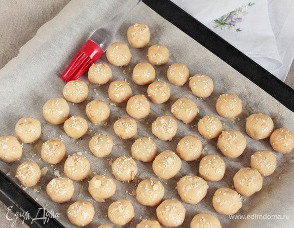 Яйцо куриное (1 шт.) взбить вилкой и смазать шарики. По желанию можно посыпать кунжутом. У меня была в закромах смесь кунжута и ломаных миндальных лепестков, этой смесью и посыпала.