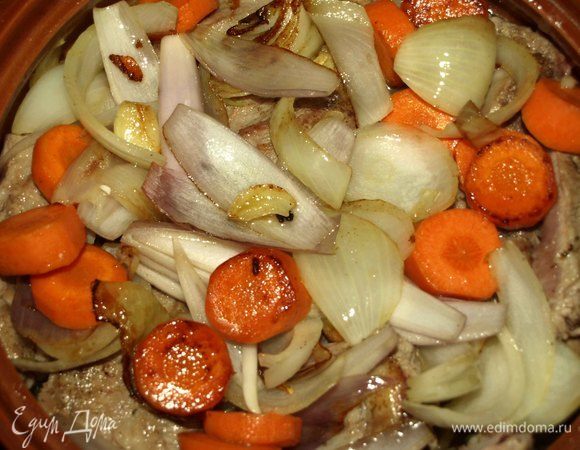 На шалфей укладываем обжаренные свиные ребра. Выкладываем на мясо обжаренные овощи и добавляем куриный бульон. Закрываем крышкой и отправляем на 40 минут в заранее разогретую до 200°С духовку.