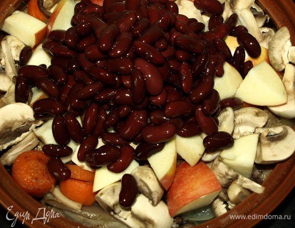 Через 40 минут достать из духовки мясо и добавить к остальным ингредиентам грибы, яблоки, фасоль. Посолить и поперчить по вкусу. Закрыть крышкой и отправить еще на 20 минут в духовку. 