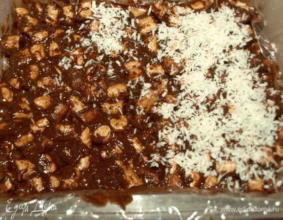 В форму выкладываем пищевую пленку так, чтобы края пленки выходили за пределы формы (так будет легче достать лакомство из формы). Выкладываем шоколад с маршмеллоу. Разравниваем и сверху посыпаем кокосовой стружкой (можно посыпать цветной стружкой). И отправляем в холодильник для застывания. 