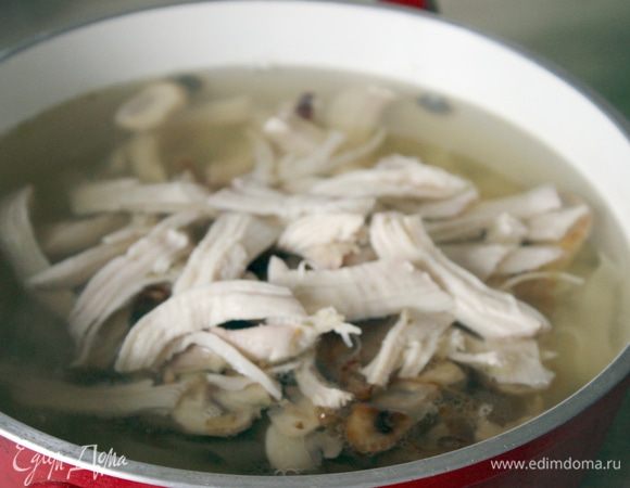 Добавить в бульон лапшу, грибы с луком и отделенное от кости куриное мясо. Прогреть на медленном огне.
