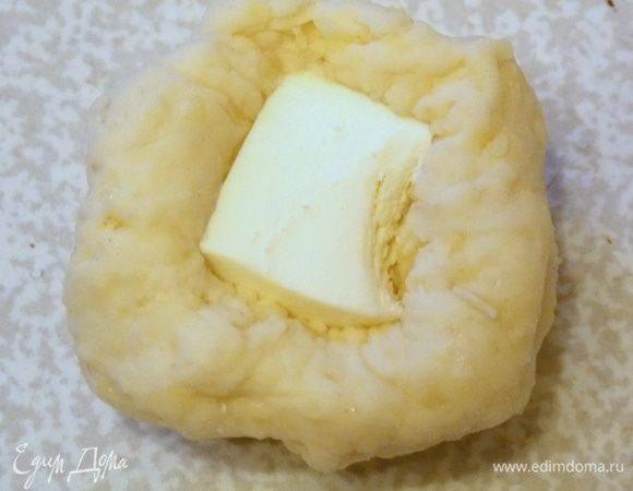 Взять шарик теста, немного раздавить, положить сыр, защипнуть края и придать ему форму шара.