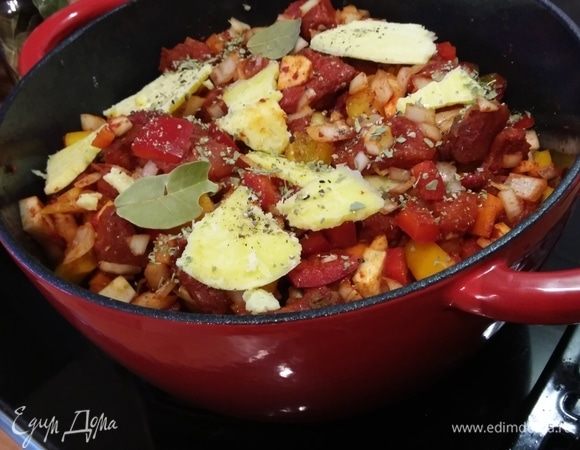 Добавить лавровый лист, сухой майоран и сливочное масло хлопьями. Накрыть крышкой и отправить в заранее разогретую до 220–240°С духовку на 50 минут. 