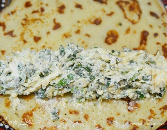 Выложите начинку на край блина.