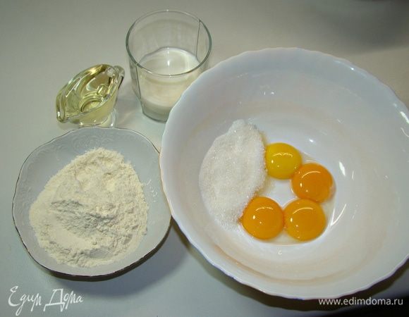Приготовить белый бисквит. Для этого венчиком смешать в миске желтки, сахар, муку, влить теплое молоко, растительное масло.