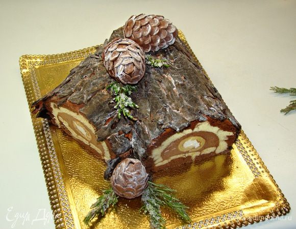 Остывшее «поленце» обмазать оставшимся кремом и сверху прикрепить шоколадную кору. Украсить на свой вкус.