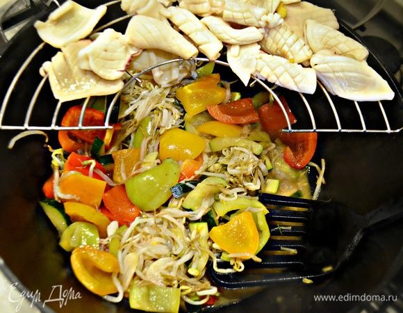 Далее в хорошо разогретом воке или глубокой сковороде моментально обжарить бланшированные кальмары, затем отложить их на решетку. 