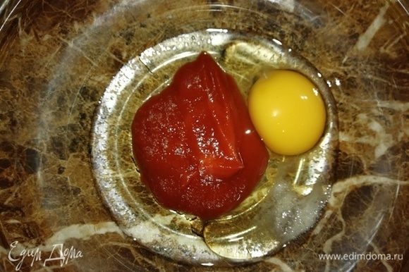 Готовим пасту. В миску выкладываем томатную пасту, яйцо, подсолнечное масло, соль.