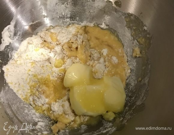 Добавьте цедру лимона и понемногу вводите мягкое сливочное масло, продолжая вымешивать тесто.