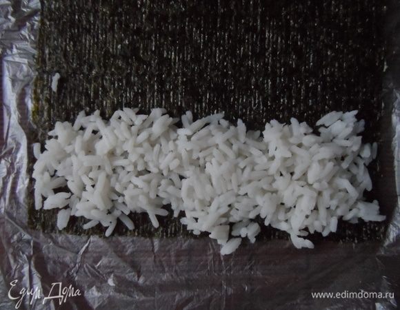  На другой край выложить рис 4–5 см шириной, посередине риса — огурец и рыбу.