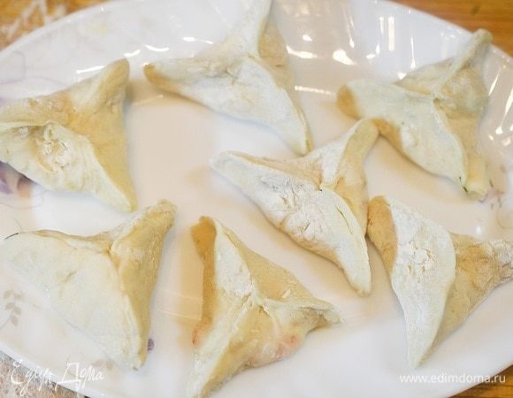 Скрепите края пельменей, сформировав треугольник.