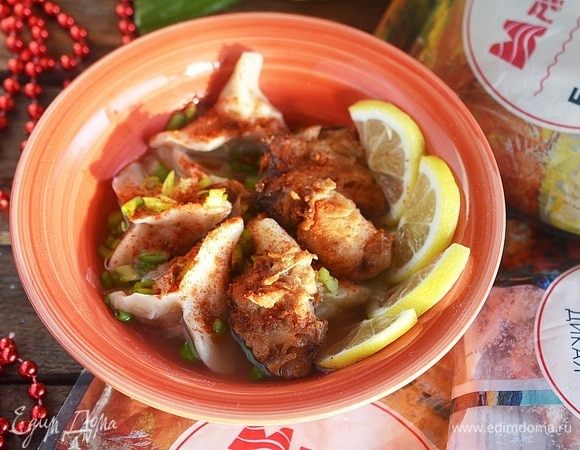 В тарелку выложите немного пельменей, сверху положите кусочек жареного рыбного филе. Подайте с ломтиками лимона и посыпьте молотым чили и зеленым луком.