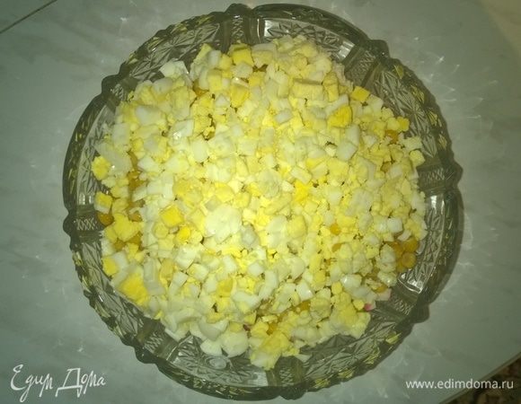 Высыпаем порезанные куриные яйца в готовую вазу для салата.