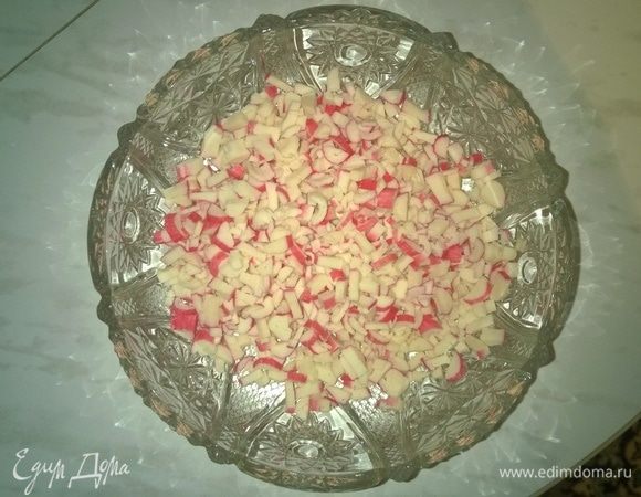 Добавляем порубленные крабовые палочки к нарезанным куриным яйцам в общую салатницу.