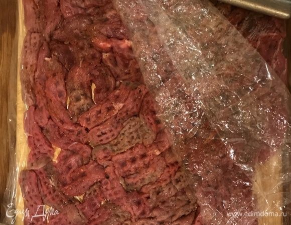 Нарезать поперек волокон на ломтики длиной по 5–6 см. Выложить на разделочную доску, поперчить, посолить, накрыть пищевой пленкой, отбить.