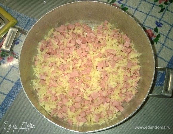 Берем половину от протертого на терке сыра, т.е. 100 г, и смешиваем его с порубленной вареной колбасой. 