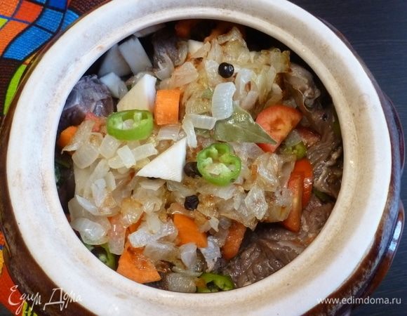 Складываем в глиняный горшок сначала слой нарезанных овощей (сельдерей, морковь, помидоры, чили), половину обжаренного лука. Затем кладем кусочки лосятины. Воду, в которой она вымачивалась, выльем. 
Закроем мясо остальной частью овощей и обжаренного лука.