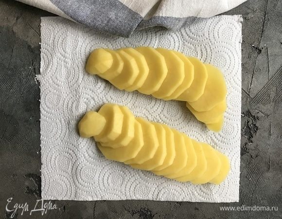 Духовку предварительно разогреть до 180°С. Картофель почистите и нарежьте на тонкие кружочки.