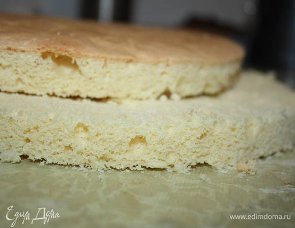 Берем один бисквитный корж. Обрезаем ровно края и разрезаем его на две части. 