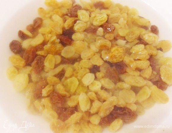 Изюм без косточек залить кипятком и оставить примерно на 5 минут.