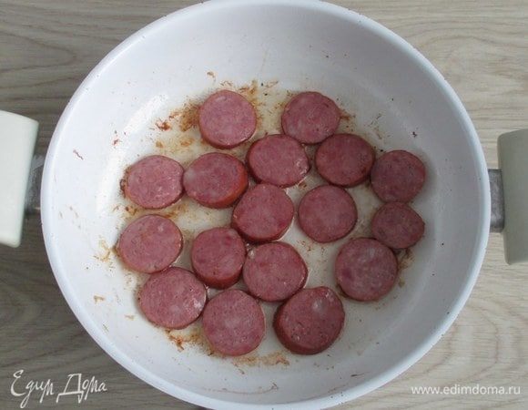 После ребер обжарьте кусочки колбасы и тоже уберите их на время.