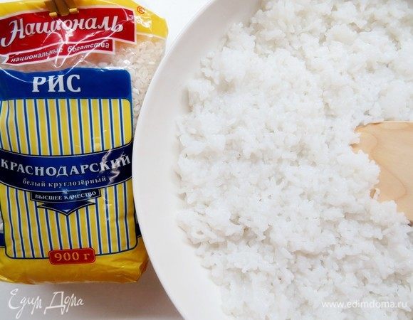 Рис Краснодарский ТМ «Националь» отвариваем согласно инструкции на упаковке. Для суши-торта нам понадобится 2 стакана готового риса. Перекладываем отваренный рис в посуду с  широким дном и поливаем по вкусу рисовым уксусом. Деревянной лопаткой перемешиваем режущими движениями снизу вверх. Накрываем мокрым полотенцем и оставляем остывать. 