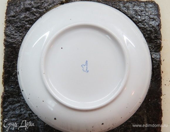 Достать из упаковки 4 листа нори, подобрать тарелку в размер диаметра торта (у меня примерно 20 см) и обрезать по контуру тарелки листы нори, придав им форму окружности.