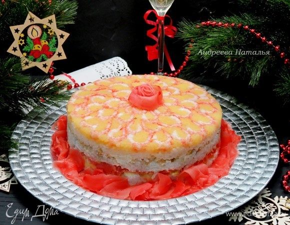 Ставим салат в холод на 1 час. Затем аккуратно переворачиваем на блюдо и снимаем форму. По желанию, края тортика можно оформить маринованным имбирем. Боковую поверхность салата можно также обклеить листами нори, но и без них закусочный торт смотрится очень эффектно.