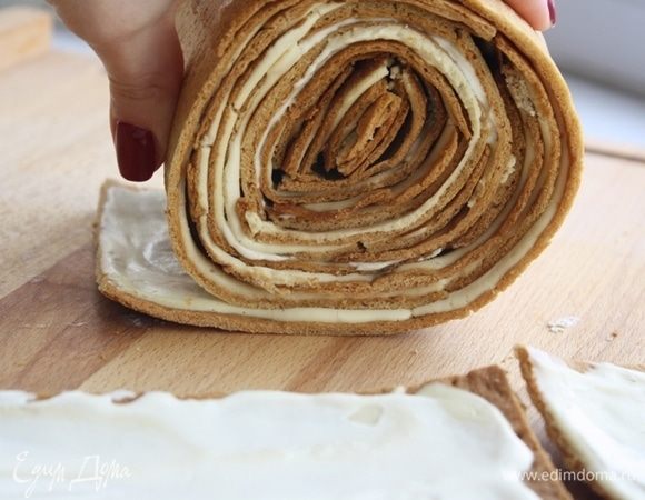 Когда коржи пропитаются и станут мягкими, мы сможем их завернуть вот в такой рулет. Начните с одной полоски, скрутите ее в рулет. Сначала она будет ломаться, продолжайте, сверху оберните второй полоской, третьей и т.д. Рулет будет очень хорошо сворачиваться и приобретет нужную форму.