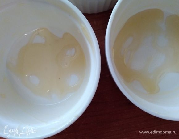 Рамекины смазать сливочным маслом, влить по 1 чайной ложке меда. 