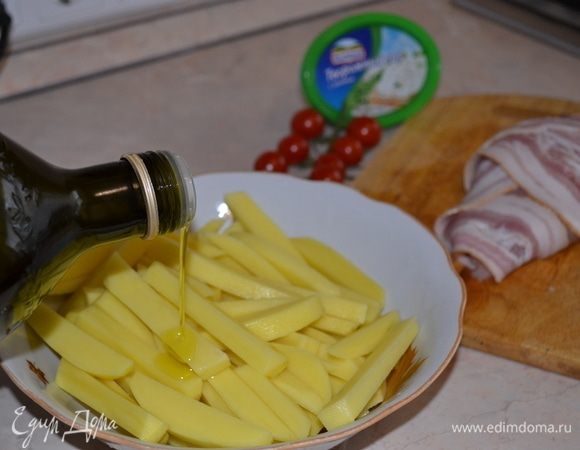 Филе обернуть беконом. Картофель почистить, нарезать брусочками. Посолить, добавить оливковое масло, перемешать.