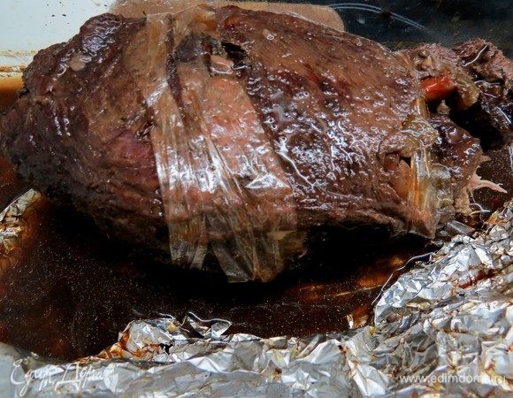 Свернуть мясо в рулет, натереть сверху солью и перцем и обмотать кулинарной нитью (у меня нить закончилась, я делала полосы из рукава для запекания, чтобы зафиксировать правильное положение).
Нагреть 3 столовых ложки оливкового масла в глубокой сковороде, обжарить рулет со всех сторон. Залить 200 мл красного вина, дать испариться спирту, влить 1 стакан обезжиренного бульона. Накрыть фольгой и отправить в предварительно нагретую духовку до 180°С на 1,5 часа. Периодически добавлять бульон и переворачивать рулет. 