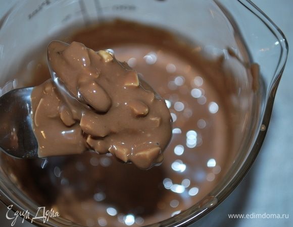 Достать из морозильной камеры финики, опустить финики в шоколад с орехами.