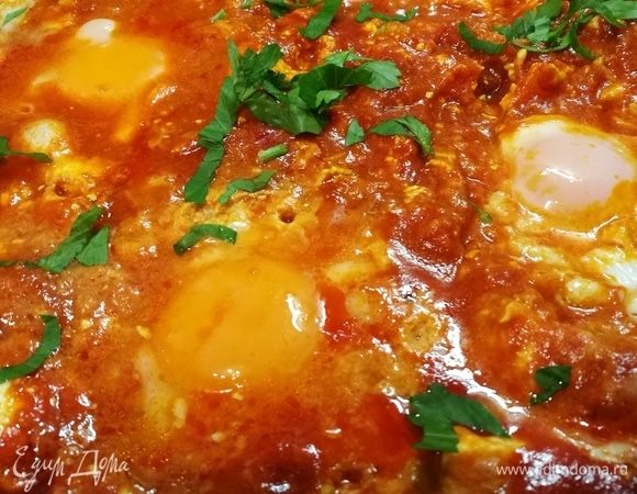 Если вы хотите закончить шакшуку на плите, вмешайте кубики феты в томатный соус. Сделайте 6 углублений в соусе. Аккуратно влейте яйцо в каждое углубление, затем осторожно перемешайте яичные белки, чтобы они немного смешались с томатным соусом, стараясь не повредить желтки.