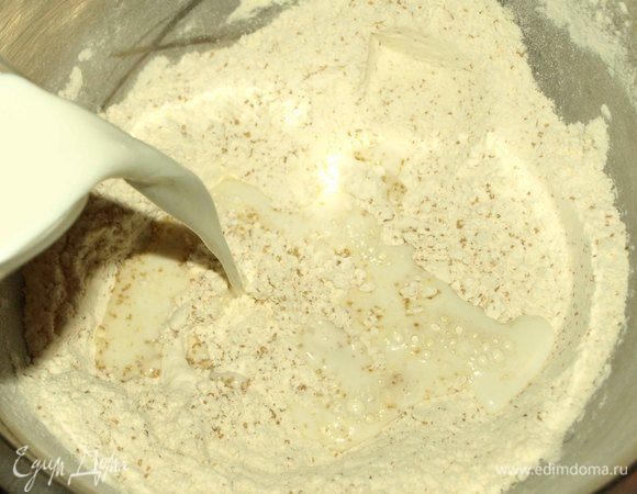 Муку просеять, добавить сахар, соль, разрыхлитель. Постепенно добавляем молоко и замешиваем тесто.